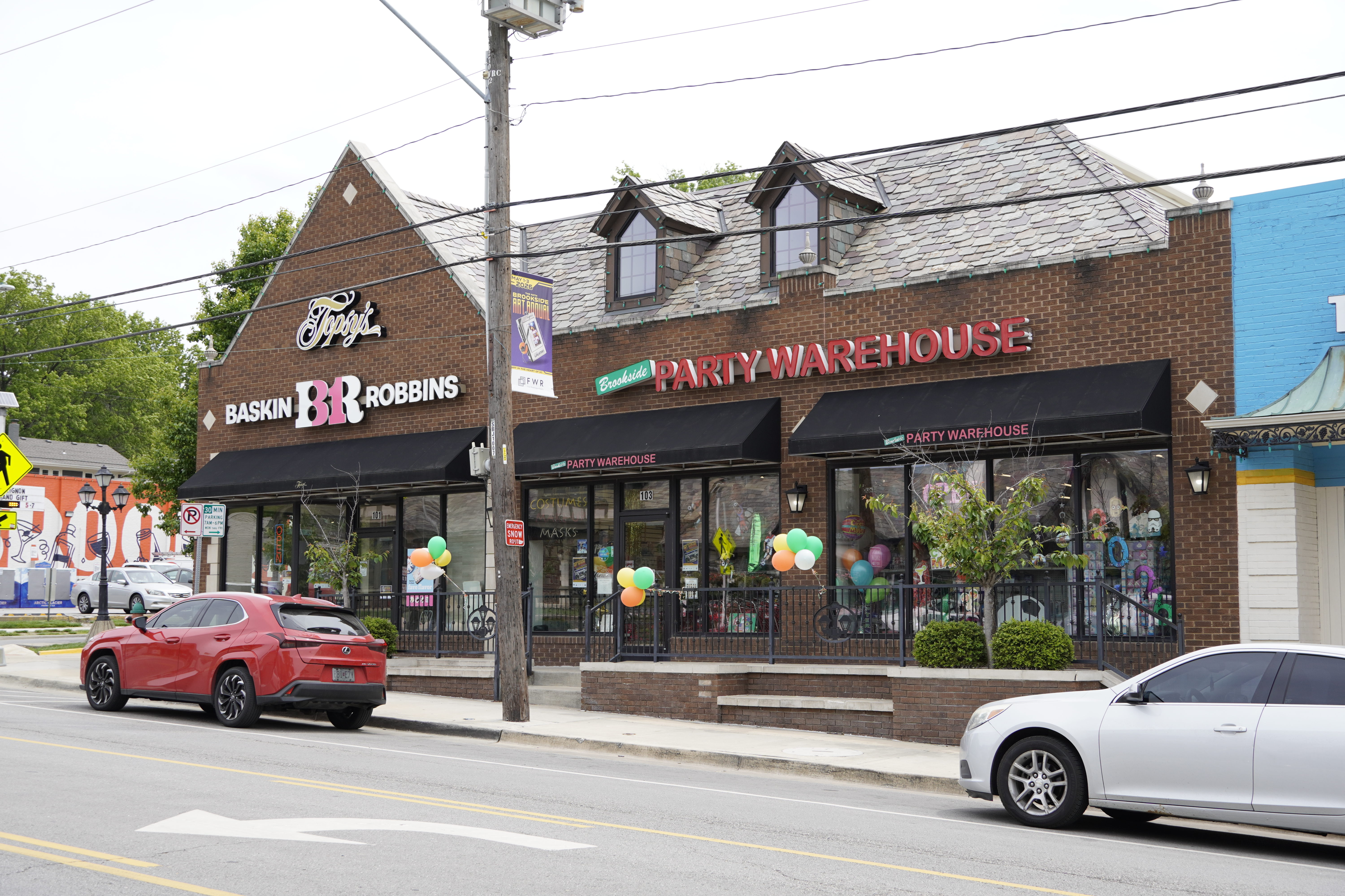 Bright party-supply aisles inside Brookside Party Warehouse with rainbow plates, banners, and themed tableware.